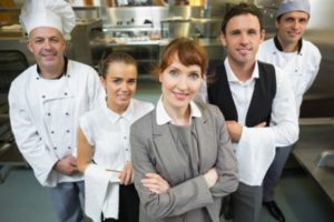 Female hospitality manager with her restaurant team with property compliance responsibility